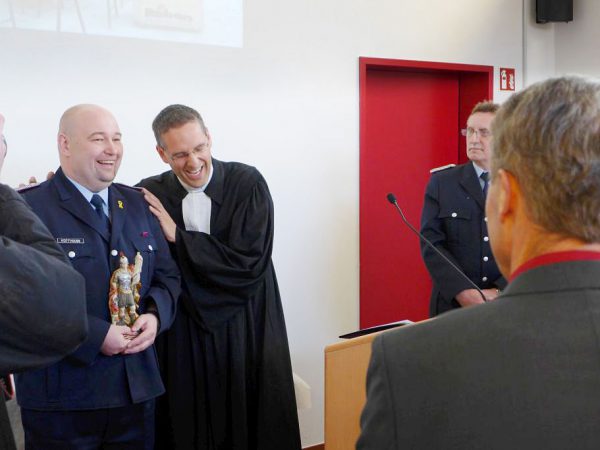 Pfarrer Kautz segnet Ortswehrführer Hofmann der den Heilige Florian in Handen hält